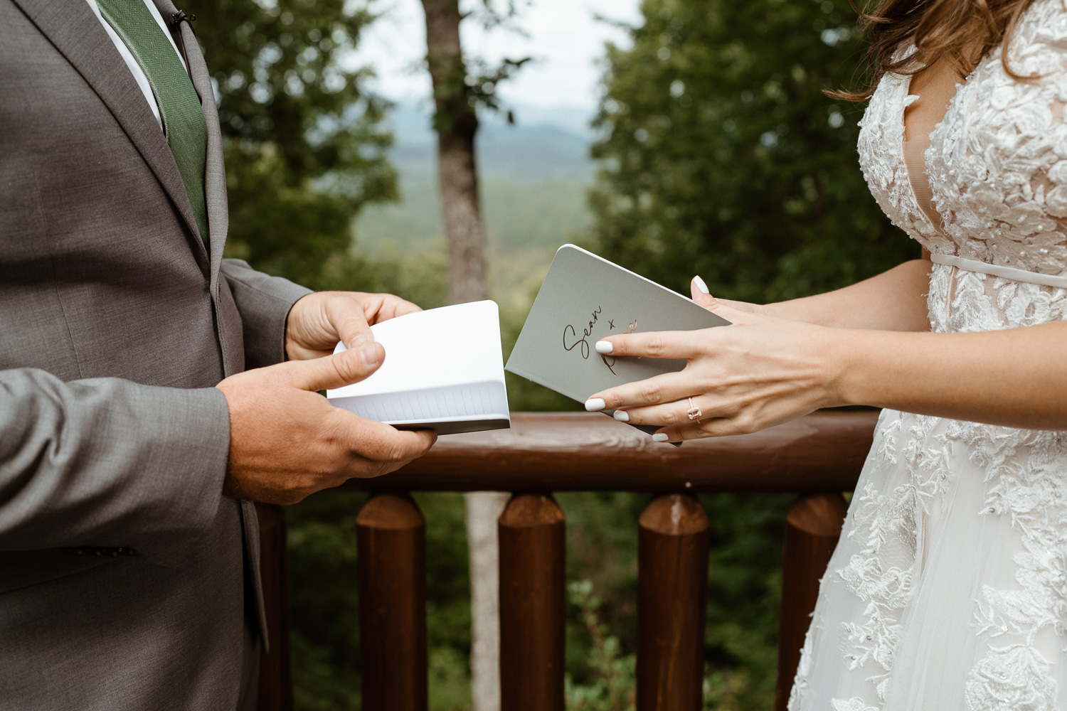 Bride and Groom's hands and vow books, reading vows at their Asheville Elopement